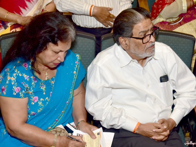 Late Shri Ukabhai and Nalini ji writing their pledge of $10,000